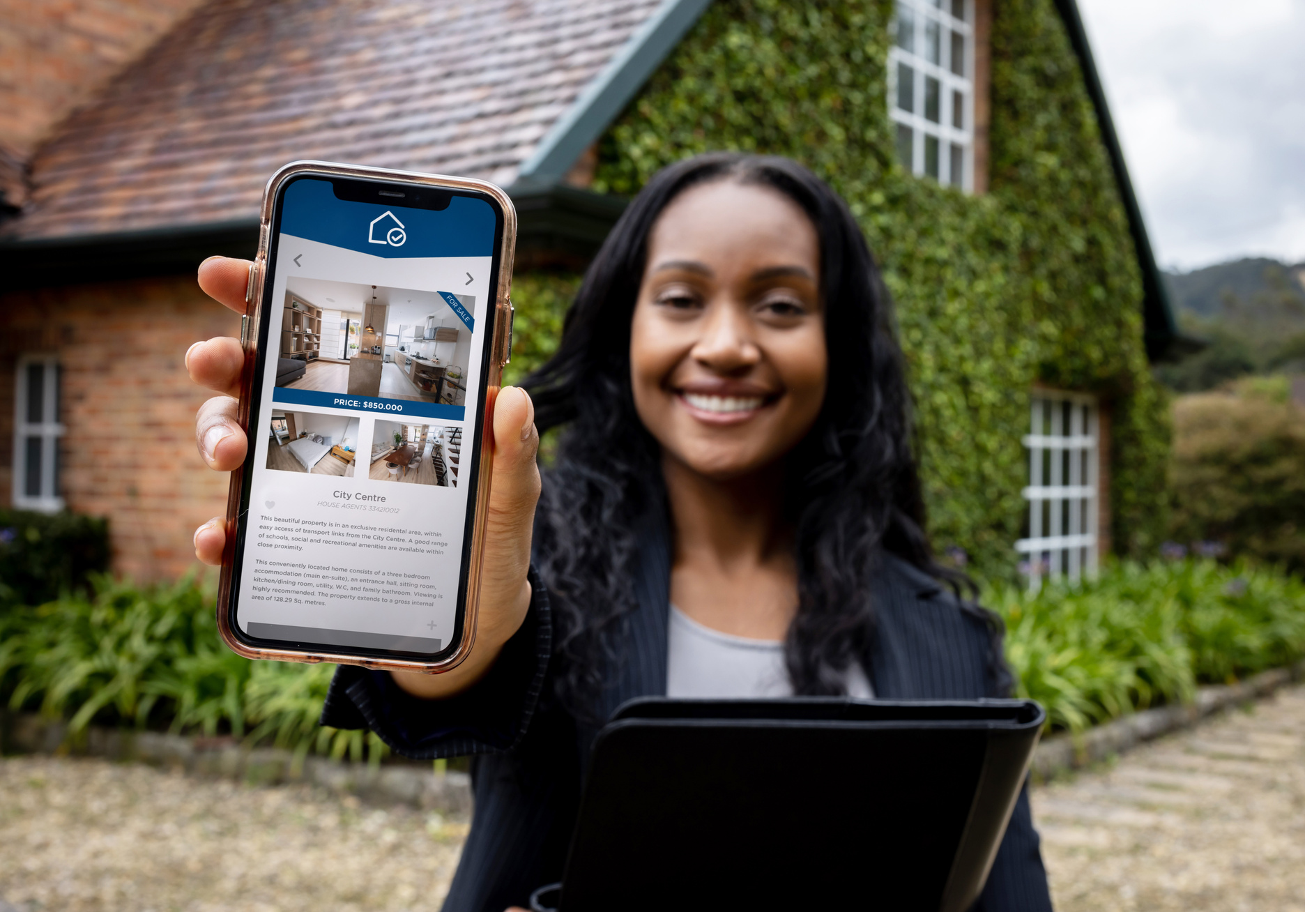 Happy real estate agent using a mobile app to list properties